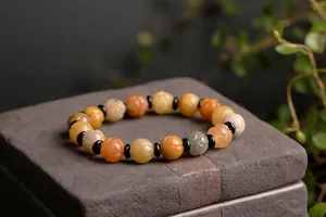 Detailed view of carved natural stone beads with floral motifs on a zen stone base