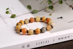 Detailed close-up of carved natural stone lotus beads in orange and yellow gradient