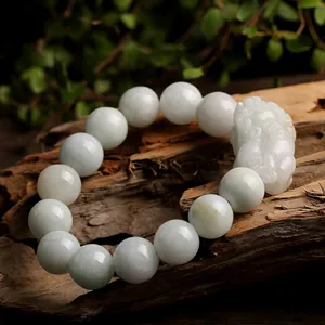 Natural jade beads bracelet with hand-carved Pixiu charm on a rustic wood base