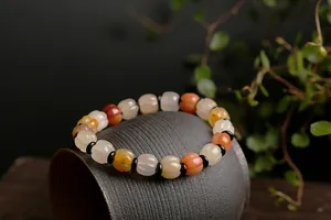Detailed close-up of orange carnelian and white pumpkin-shaped jade beads on a bracelet
