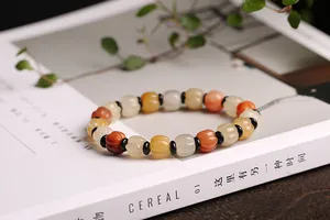 Detailed view of pumpkin-shaped jade beads in warm orange and yellow tones with black spacers