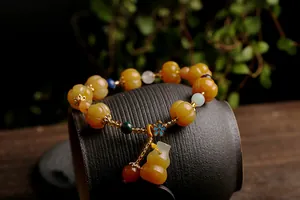 Detail of yellow pumpkin beads and a gourd pendant on an ethnic style beaded bracelet