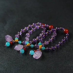 Set van drie amethist armbanden met hangers van ruwe steen en etnische kralen