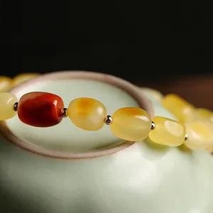 Natural yellow beeswax barrel bead bracelet with jadeite lock and red accent bead