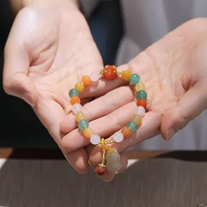 Detailed shot of Chinese style multi-color gemstone beads with jade gourd and flower charm