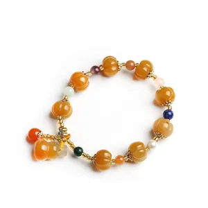 Ethnic beaded bracelet with yellow carved pumpkin beads and gourd pendant for women