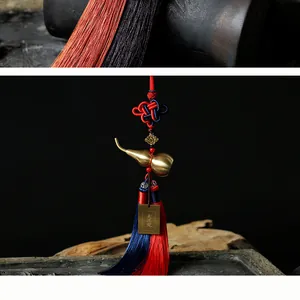 Makro-Detail von Messingkürbis-Anhänger mit chinesischem Knoten und Seidenquasten