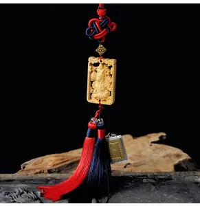 Macro view of hand-carved wood Buddha pendant with red tassel for car interior decor