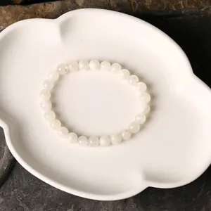 Natürliches weißes Mondstein-Perlenarmband für Damen auf Keramiktablett