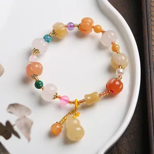 Macro detail of multicolored pumpkin jade beads and gourd pendant on chinese style bracelet