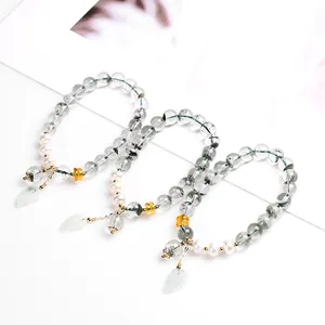 Close-up of green phantom quartz bracelet with pearls and jade leaf pendant details