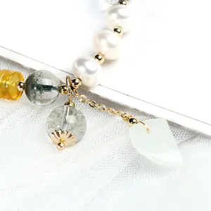Detailed close-up of beaded bracelet with green phantom quartz and freshwater pearls