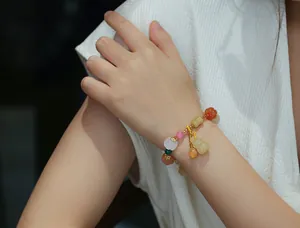 Close-up of retro ethnic beaded bracelet with pumpkin beads and gourd pendant on wrist