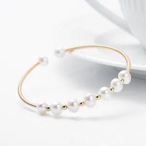 Macro view of flexible 14K gold filled bracelet featuring nine natural freshwater pearls