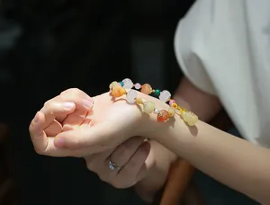 Detailed shot of multi-color pumpkin and floral beads with gold spacers on wrist