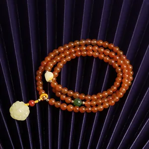 Macro view of multi-layer cherry red agate bracelet with yellow rose amber and gold accents