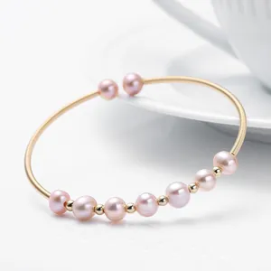 Detail of 14K gold-filled cuff bracelet featuring natural pink pearls and textured metal wire