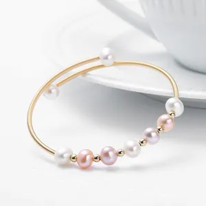 Detail view of natural freshwater pearls on 14K gold filled elastic bracelet with a white cup
