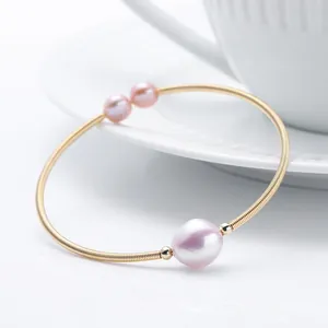 Detail of 14K gold filled wire bracelet with a large pink freshwater pearl and two small beads