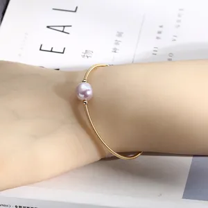Detailed view of an elegant 14K gold filled bracelet featuring a single pink freshwater pearl