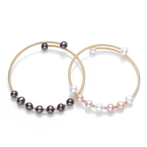 Detail of 14K gold-filled wire wrap bracelet with premium freshwater pearls in two colors