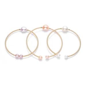 Detailed view of three 14K gold-filled spiral bracelets with colorful freshwater pearls