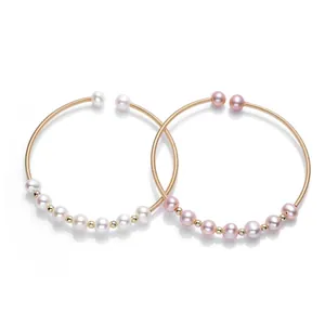Detail of 14K gold-filled coil bracelets with natural white and lavender pearls