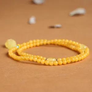 Macro detail of natural amber beads bracelet with blue accents and Zen style design