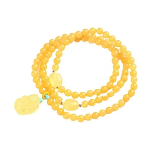 Natural yellow amber beeswax round bead triple wrap bracelet with carved amulet and turquoise