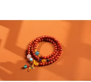 Macro-opname van gelaagde rode agaat armband met barnsteen bladbedeltje in Zen-stijl