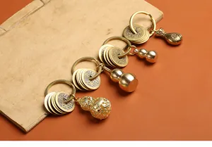 Détails de quatre porte-clés en laiton antique avec pièces et gourdes sculptées