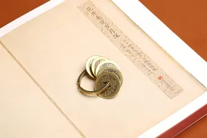 Gros plan du porte-clés en laiton avec pièces de monnaie sur fond de livre ancien