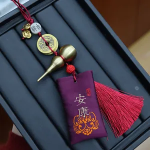 Detail eines Vintage-Messing-Kürbis-Anhängers mit lila Seidenbeutel und roter Quaste