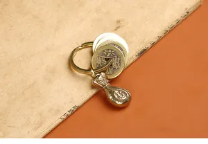 Vue détaillée d'un porte-clés en laiton avec pièces anciennes et pendentif Fú gravé