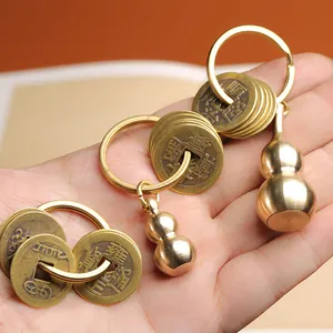 Porte-clés en laiton avec cinq pièces impériales et gourde Wu Lou tenu dans la main