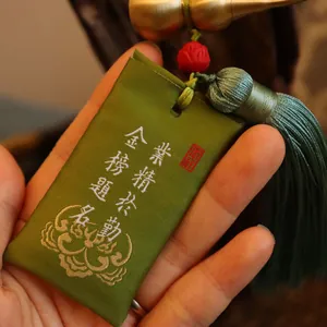 Nahaufnahme des grünen Seidengewand-Sachets mit Stickerei und Messing-Kürbis-Detail
