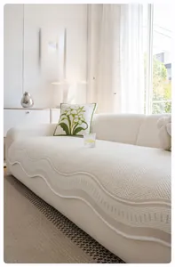 Close-up of summer cooling silk sofa cover featuring wave edges and textured cream fabric