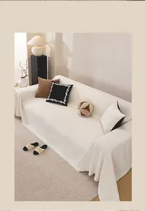 Detail of cream chenille sofa cover with thick textured weave and fringe edges