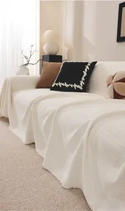 Detail of chenille sofa cover showing vintage cream weave texture and fringed edges