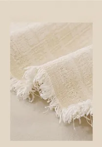 Detail of vintage chenille sofa cover with textured jacquard and elegant long fringe edges