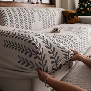 Elastischer Jacquard-Sofaüberzug mit grauem Blattmuster wird auf die Couch gespannt