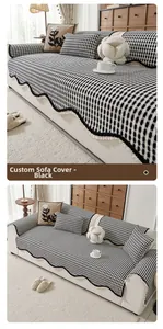 Close-up of black and white checkered chenille sofa cover with wavy edges and tassels