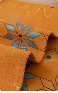 Detail of bohemian jacquard chenille fabric showing thick texture and orange geometric patterns
