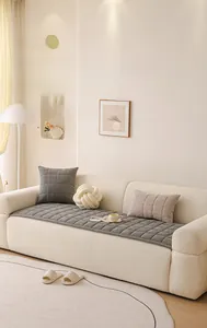 Close-up of gray quilted chenille sofa cushion with thick square pattern and matching pillow