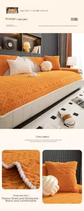 Detail of thickened orange fleece sofa cover with jacquard texture and white pompoms