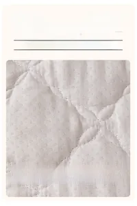 Detail of plush sofa cover back showing non-slip silicone particles and quilted texture