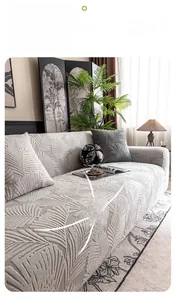 Detail of light beige elastic sofa cover featuring embossed feather texture and matching pillow