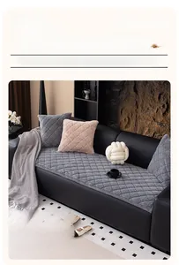 Close-up of gray quilted plush sofa cover with diamond patterns and matching pillows