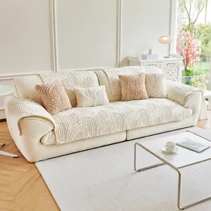 Detail view of cream-colored plush sofa cover with vertical quilted stripes and soft texture