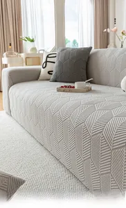 Close-up of light grey stretch sofa cover with 3D leaf texture and matching pillowcase